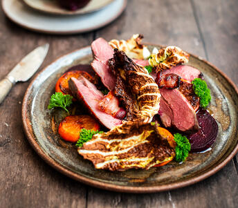 cooked grouse with vegetables on platter
