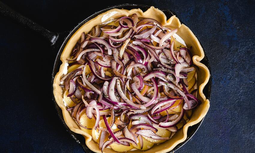 bake potato, red onion and goats cheese galette on baking tray 