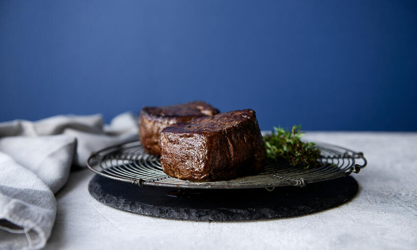cooked steak on resting board
