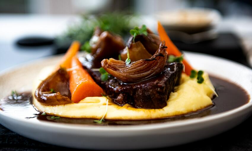 braising steak in onion gravy with carrots and mashed potatoes 
